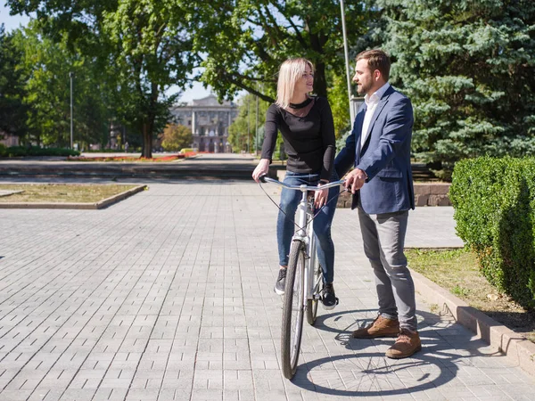 Un tipo está montando a su chica en una bicicleta — Foto de Stock