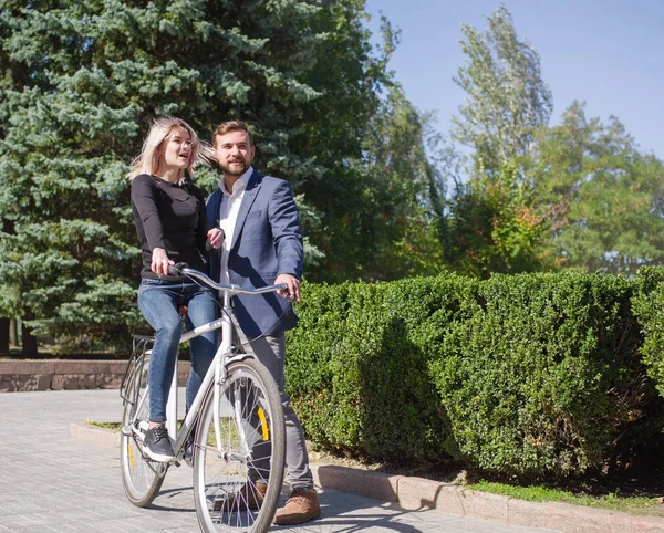 Un tipo está montando a su chica en una bicicleta — Foto de Stock