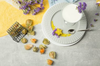 Doğal bir milkshake ve tropikal meyve çok renkli bir arka plan üzerinde bir görünüm yukarıdan. Dekoratif çiçek ve bir kaşık ile bir tatlı. Restoran tatlı Gurmeler için.