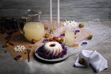 Gri bir ahşap zemin üzerine bir yeni yıl kompozisyon bir görünümünü yukarıda. Toz şeker, meyve suyu, içecekler, badem ve mumlar bir tatil masada bir yığın bir ev yapımı vanilyalı pasta. Kopya alanı.