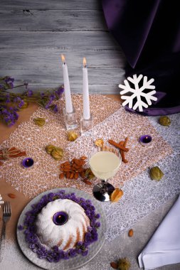 Gri bir ahşap zemin üzerine bir yeni yıl kompozisyon bir görünümünü yukarıda. Toz şeker, meyve suyu, içecekler, badem ve mumlar bir tatil masada bir yığın bir ev yapımı vanilyalı pasta. Kopya alanı.