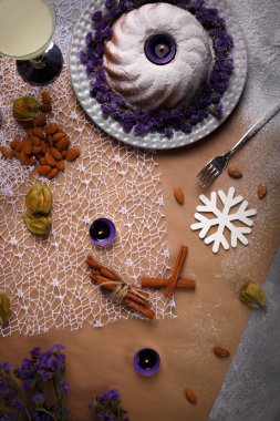 Dan yılbaşı süslemeleri tablo arka plan üzerinde renkli bir dizi yukarıda görüntüleyin. Baharatlı tarçın, badem fındık, egzotik meyveler bir geleneksel Noel kek için. Güzel mumlar, çiçekler ve kar taneleri.