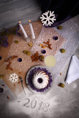 Baharatlı tarçın, gevrek fındık, tablo arka plan üzerinde süslü bir plaka üzerinde egzotik meyve organik çikolatalı kek. 