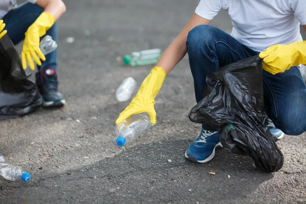 儿童的腿和双手在黄色乳胶手套的特写照片 孩子们拾起塑料垃圾 自然保护 污染概念 复制空间 — 图库照片
