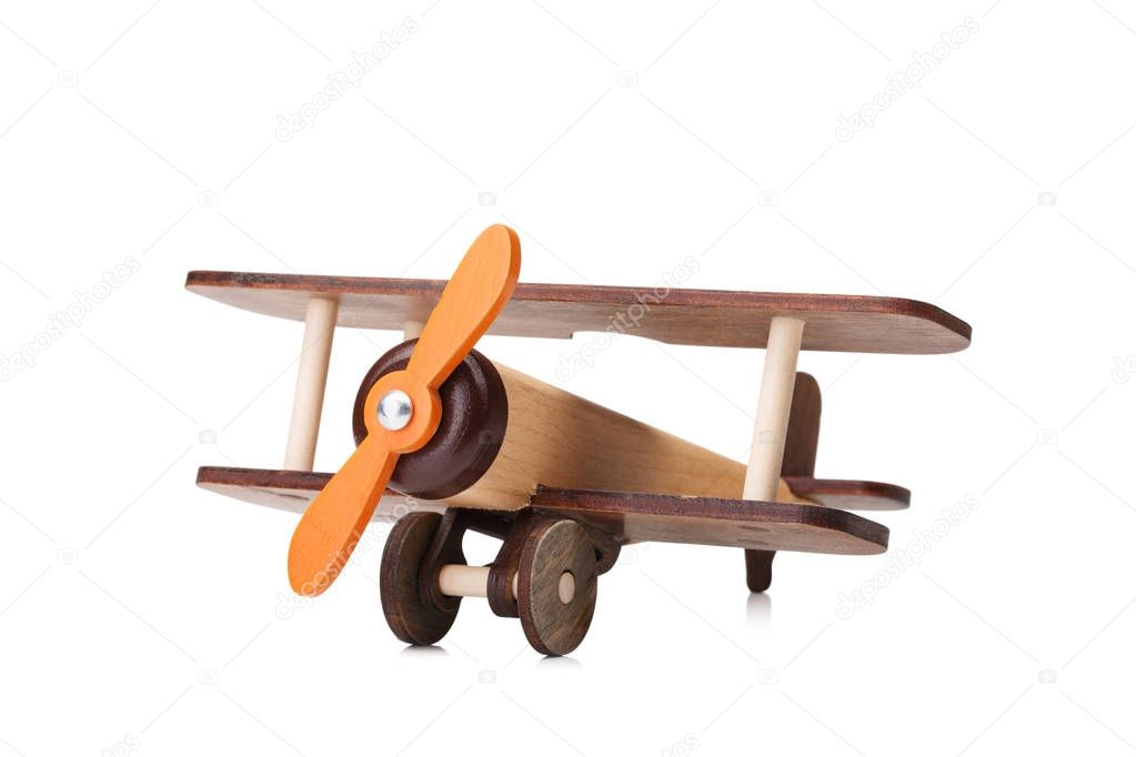 close-up picture of brown wooden toy airplane isolated on white background. 