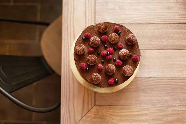 yukarıdan bir lezzetli çikolatalı kek ile açık kahverengi ahşap arka planı kremsi bir katmanda görüntülemek.