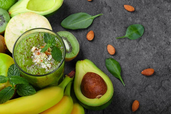 Bir gri tablosudur arka planda bir canlandırıcı ve egzotik yüzlü vitaminler ve kivi dolu bir manzara yukarıdan. Olgun muz, organik avokado, kesme kivi ve elma bir masa üzerine bir kompozisyon.