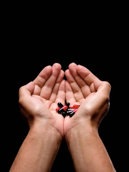 Nahaufnahme Geöffneter Handflächen Mit Roten Und Schwarzen Kapseln Mit Medikamenten — Stockfoto