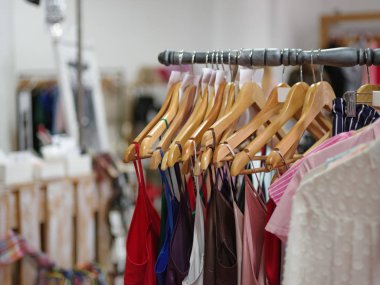 Büyük ürün yelpazesine renkli elbise dükkanı arka plan üzerinde kadınlar için. Çeşitli moda renk gömlek ve elbiseler içinde pahalı bir butik. Lüks ve şık giysi askı üzerinde. Moda kavramı.