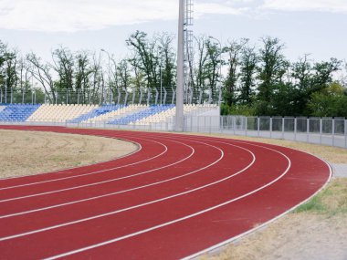 Bir yaz kırmızı izlemek eğitimler ve yarışmalar bir yeşil doğal arka plan üzerinde çalıştırmak için. Koşu parkuru spor stadyumda. Spor, açık havada, yaz konsepti. Kopya alanı.