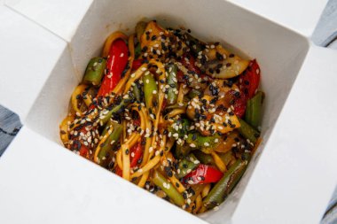 Ahşap bir masa üstünde ihracat yapmak için bir kutu içinde sebzeli erişte