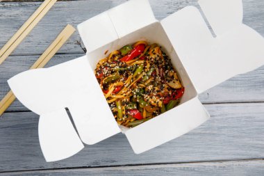 Ahşap bir masa üstünde ihracat yapmak için bir kutu içinde sebzeli erişte