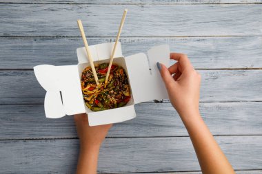 Erişte ile tavuk ve sebze bir kutu içinde. Eller. Gıda kavramı.