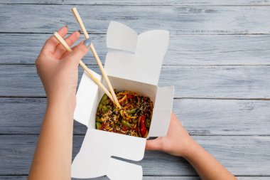 Erişte ile tavuk ve sebze bir kutu içinde. Eller. Gıda kavramı.