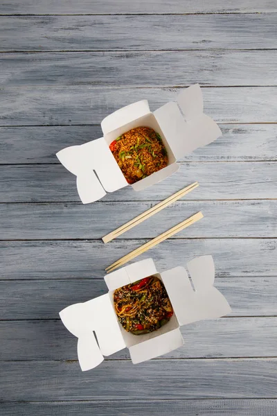 Ahşap bir masa üstünde ihracat yapmak için bir kutu içinde sebzeli erişte