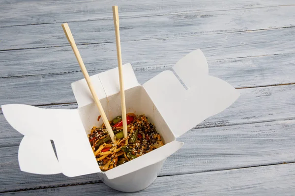 Ahşap bir masa üstünde ihracat yapmak için bir kutu içinde sebzeli erişte