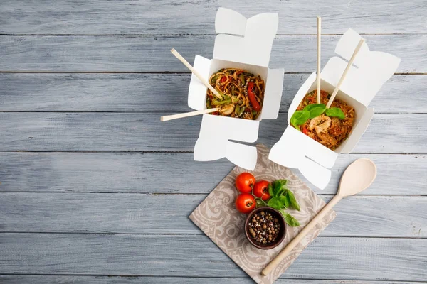 Comida chinesa em uma caixa em uma mesa de madeira. Chinês e asiático fast food . — Fotografia de Stock