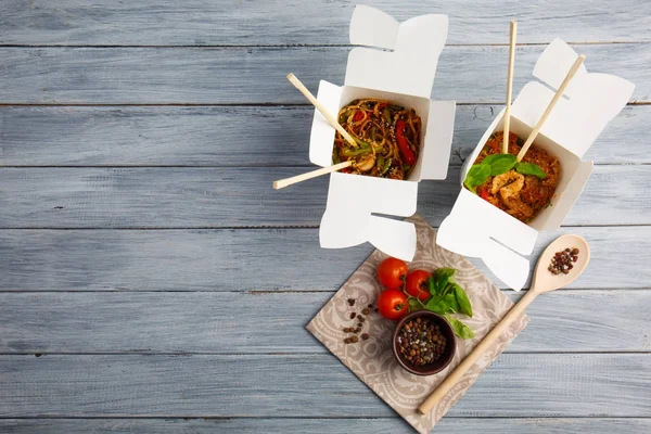 Comida chinesa em uma caixa em uma mesa de madeira. Chinês e asiático fast food . — Fotografia de Stock