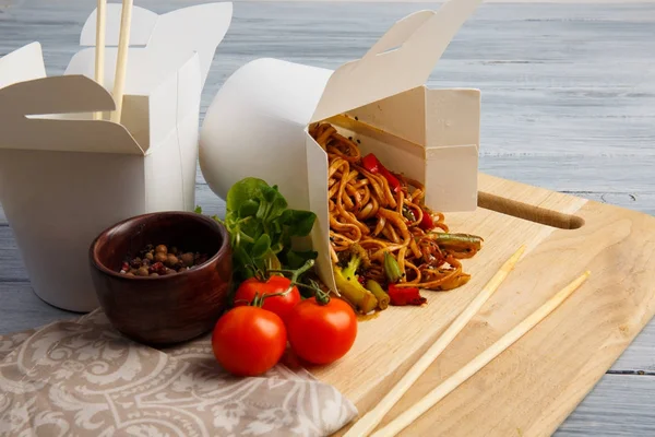 Gri bir tablo üzerinde bir kutu içinde Çin eriştesi.