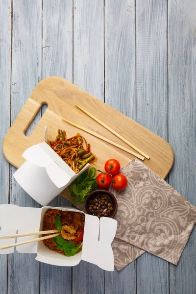 Китайская лапша в коробке на сером столе . — стоковое фото