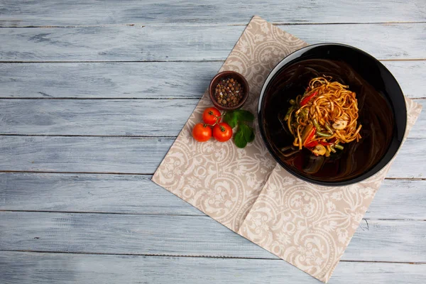 Plato chino tradicional en un plato redondo, fideos de arroz, col repollo verde y verduras fritas, tomates rojos cereza . —  Fotos de Stock
