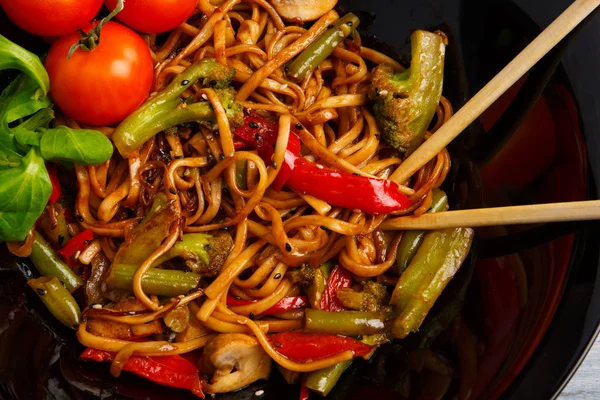 Geleneksel Çin yemeği yuvarlak tabakta, pirinç noodle, yeşil lahana lahana ve kızarmış sebzeler, kırmızı kiraz domates.