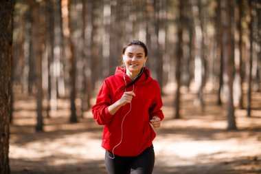 Genç esmer atlet sonbahar ormanda çalışır.