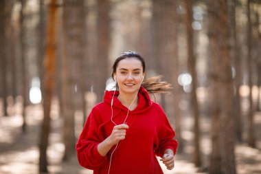 Genç esmer atlet sonbahar ormanda çalışır.