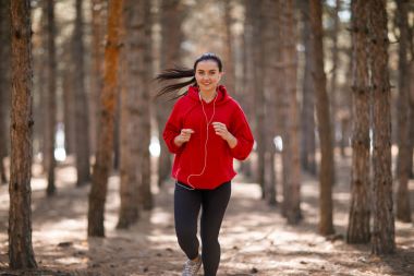 Genç esmer atlet sonbahar ormanda çalışır.