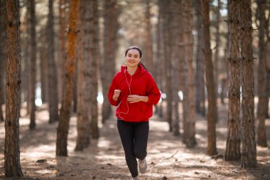 Genç esmer atlet sonbahar ormanda çalışır.