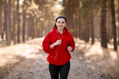 Genç esmer atlet sonbahar ormanda çalışır.