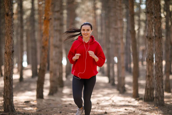 Genç esmer atlet sonbahar ormanda çalışır.
