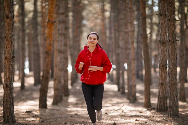 Genç esmer atlet sonbahar ormanda çalışır.