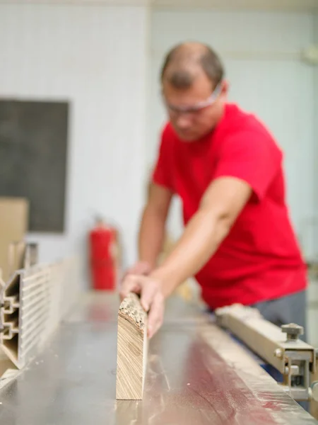 De timmerman is herverdeling de hout-bar in de werkplaats — Stockfoto