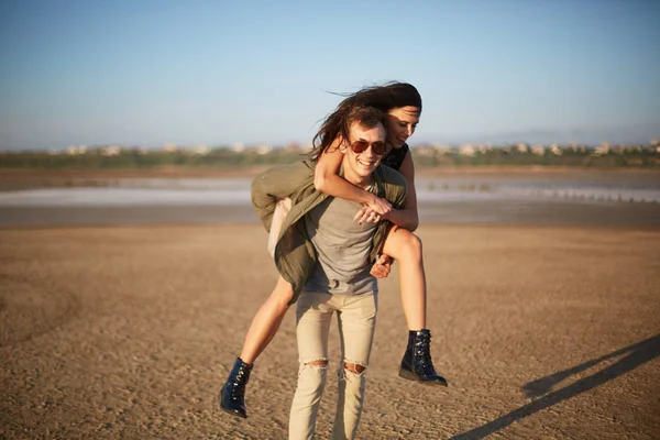 Handsome man walking with pretty girl on a back on a natural background. Romantic trip concept. Copy space. — Stock Photo, Image
