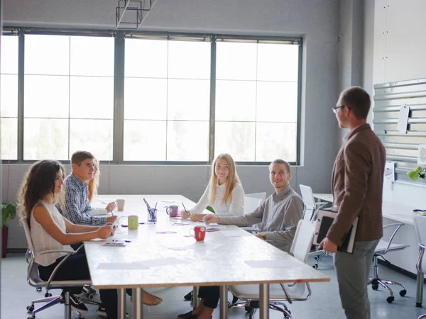 Een man vertelt zijn businessplan aan een groep van kantoorpersoneel — Stockfoto