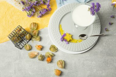 Doğal bir milkshake ve tropikal meyve çok renkli bir arka plan üzerinde bir görünüm yukarıdan. Dekoratif çiçek ve bir kaşık ile bir tatlı. Restoran tatlı Gurmeler için.