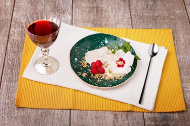 Bir sağlıklı restoran tatlı kümesi. Beyaz dondurma bir orkide çiçeği, olgun çilek ve taze nane ile bir kase. Bir tatlı ve bir kadeh şarap ahşap masa arka plan üzerinde.