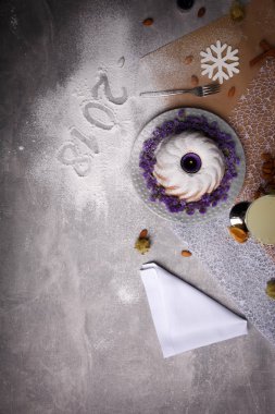 Üstten Görünüm Noel kek mor çiçekler, baharat ve pudra şekeri ve fantezi süslemeleri ile güzel bir kompozisyon. Festival çanak ve yazılı 2018 bir masa lambası arka plan üzerinde oturum açın. Kopya alanı.