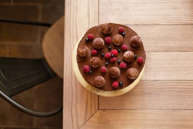 Açık kahverengi ahşap renkli bir lezzetli çikolatalı kek krem bir tabaka ile yukarıdan bir görünüm. 