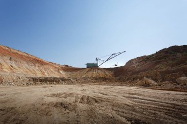 Bir endüstriyel hareketli makine Vakfı çukurda. Kum ocağında çalışan sarı Vinçler-Mobil vinç. Sanayi ekipmanları mavi gökyüzü arka plan üzerinde. Teknoloji, kargo, ticaret, ulaşım kavramı.