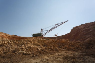 Bir endüstriyel hareketli makine Vakfı çukurda. Kum ocağında çalışan sarı Vinçler-Mobil vinç. Sanayi ekipmanları mavi gökyüzü arka plan üzerinde. Teknoloji, kargo, ticaret, ulaşım kavramı.