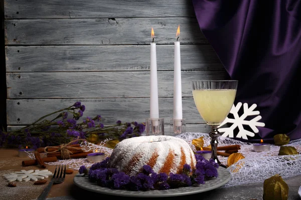 Açık gri ahşap renkli bir yeni yıl Gıda kompozisyonu. Toz şeker, meyveli içecek, tarçın ve mumlar bir tatil tablo olan bir ev yapımı vanilyalı pasta. Kopya alanı.