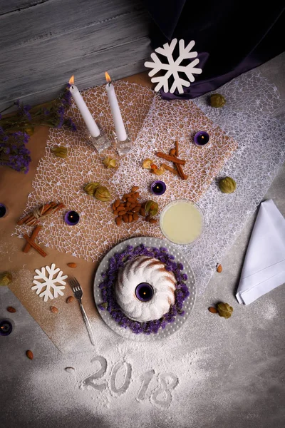 Baharatlı tarçın, gevrek fındık, tablo arka plan üzerinde süslü bir plaka üzerinde egzotik meyve organik çikolatalı kek. 