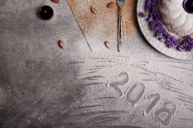 Pişmiş kek kısmi bir kompozisyon Menekşe çiçek ve mum bir merkezindeki Noel tatili için en iyi görünümü ışık gri arka plan üzerinde. Kopya alanı.