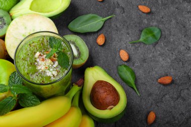 Bir gri tablosudur arka planda bir canlandırıcı ve egzotik yüzlü vitaminler ve kivi dolu bir manzara yukarıdan. Olgun muz, organik avokado, kesme kivi ve elma bir masa üzerine bir kompozisyon.