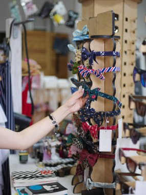 Şirin, renkli basketbol saçlar için bulanık salonu zemin üzerine alarak ihale bir kadın eli close-up. Saç aksesuarları bir mağaza seçme Gil. Saç için çok çok parlak çemberler ile bir stand.