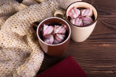 Kahve marshmallow, yün, İpek eşarp ve ahşap arka plan üzerinde kitap. Kış sıcak çikolata. Coziness kavramı.