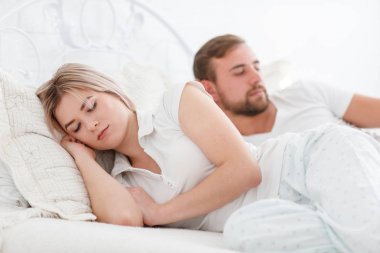 Şehvetli genç çift yatakta birlikte. Beyaz bir arka plan üzerinde izole yatak odasında mutlu çift.