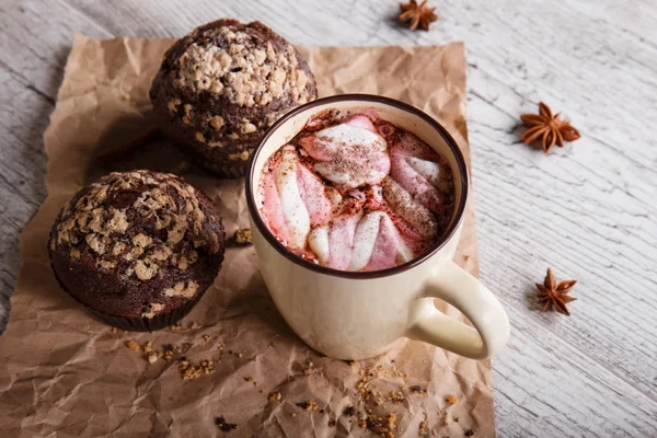 Cioccolata calda con marshmallow e cupcake su sfondo tavolo. Caffè e muffin. Dolci di caffè invernali . — Foto Stock